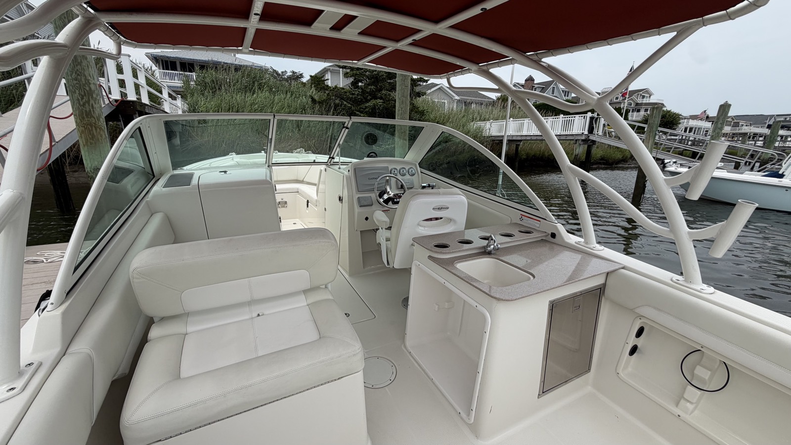 The helm and cockpit of the Sailfish under its hardtop, seating and console wiped down.